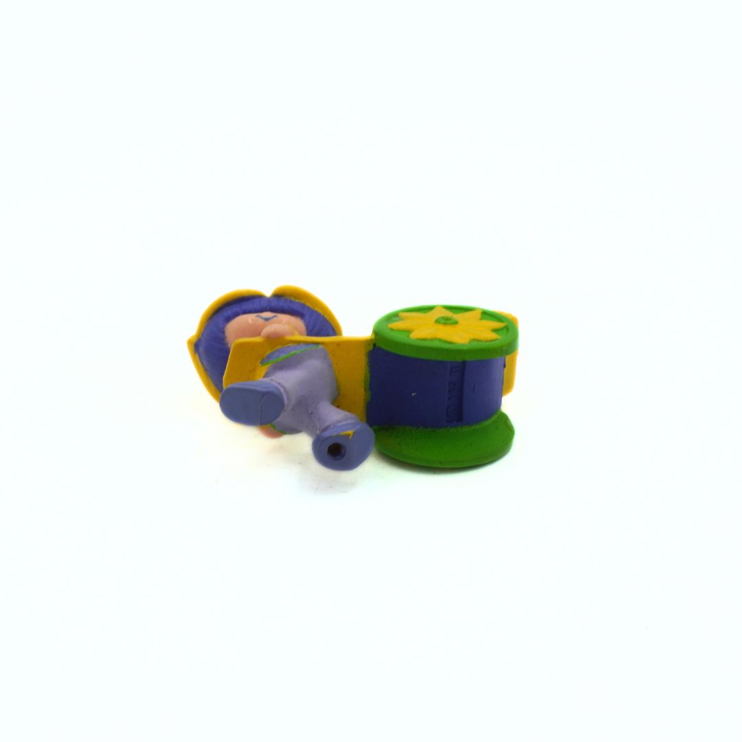 Colorful toy figure of a character with a book and flower on a white background