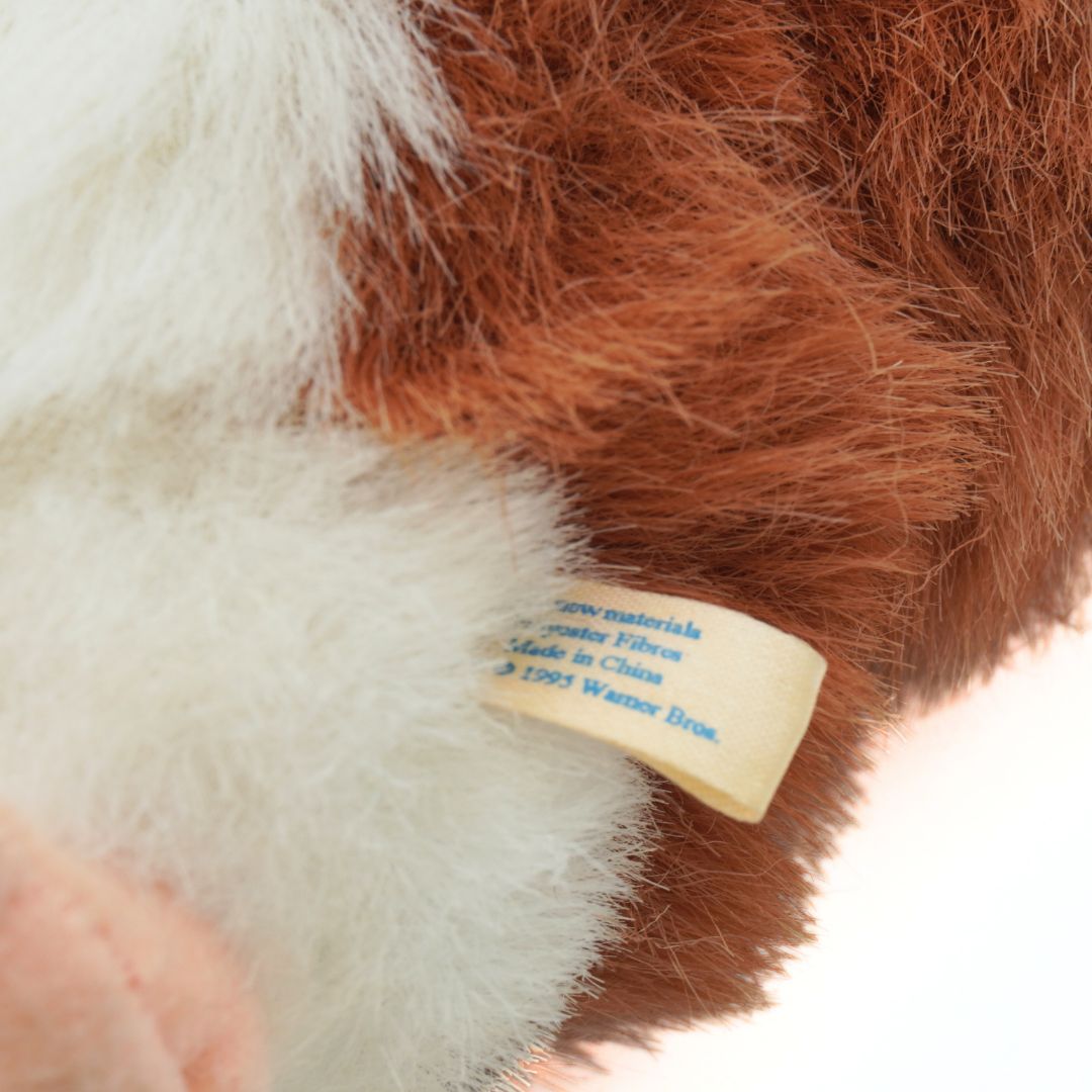 Close-up of a plush toy with a label showing materials and care instructions.