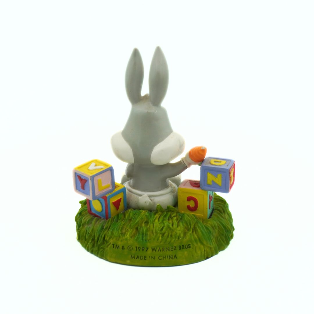 Figurine of a rabbit with colorful blocks on a grassy base, with 'Made in China' label.