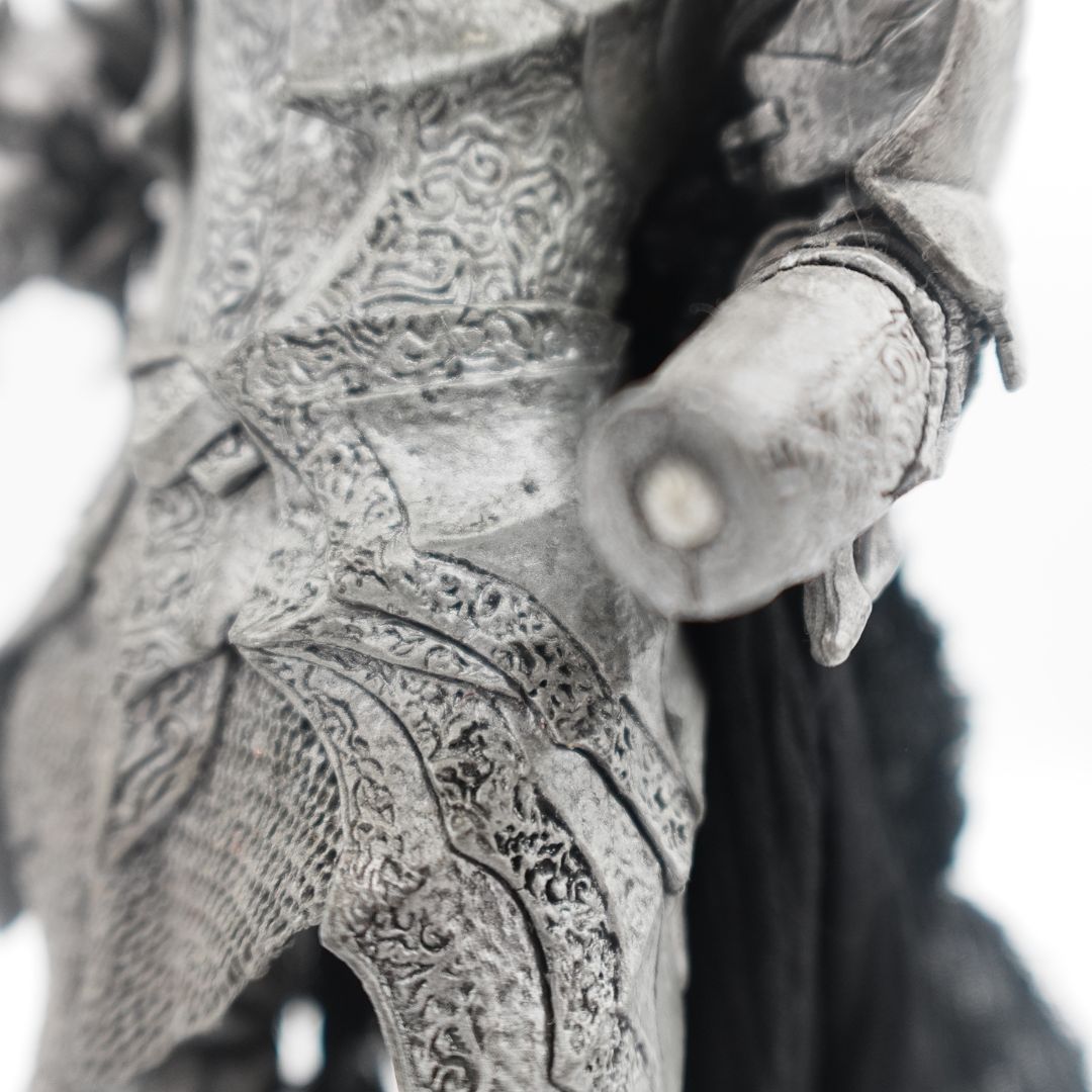 Close up of a Sauron figurine showing his missing hand with a small magnet for attachment