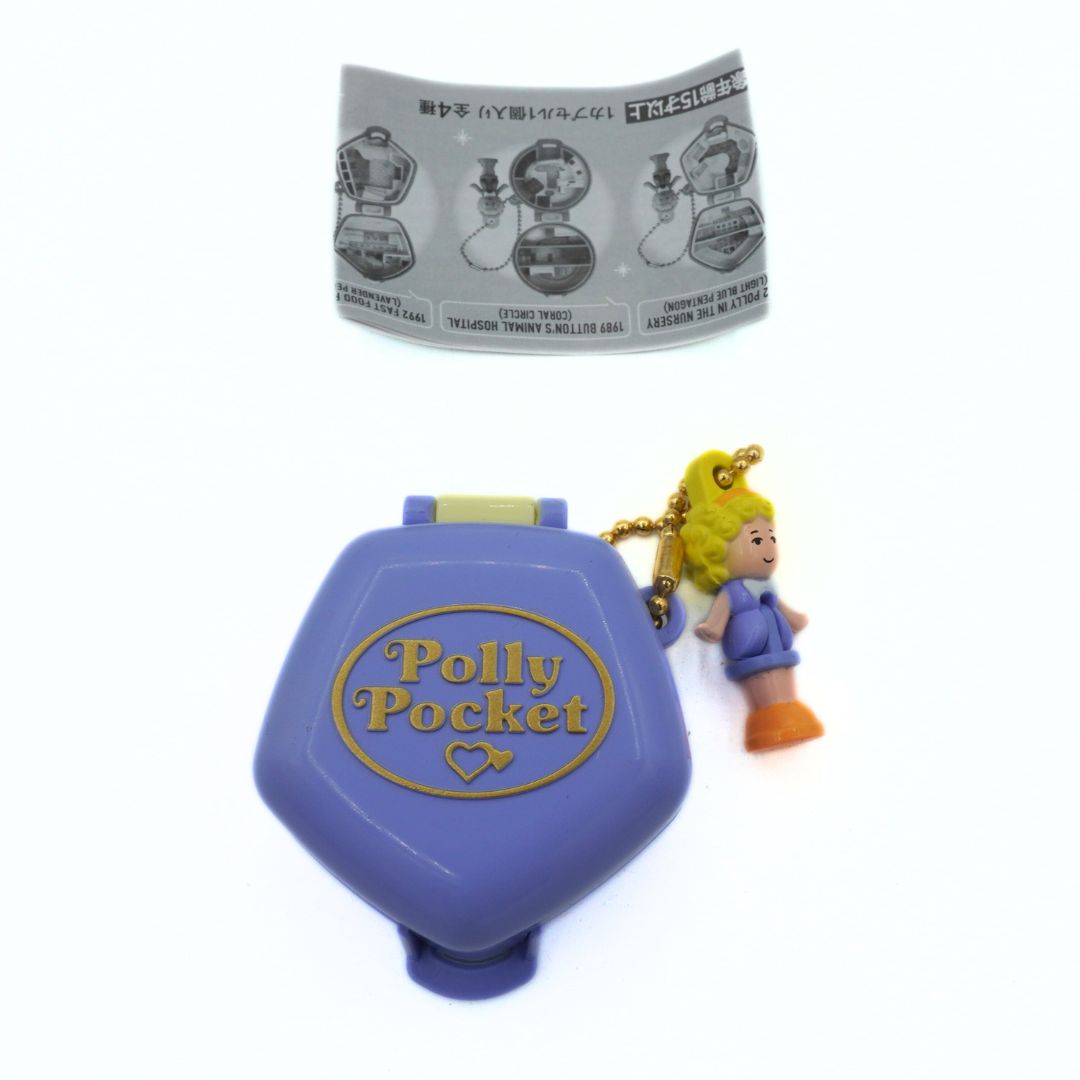 Purple Polly Pocket toy with a character figure on a white background