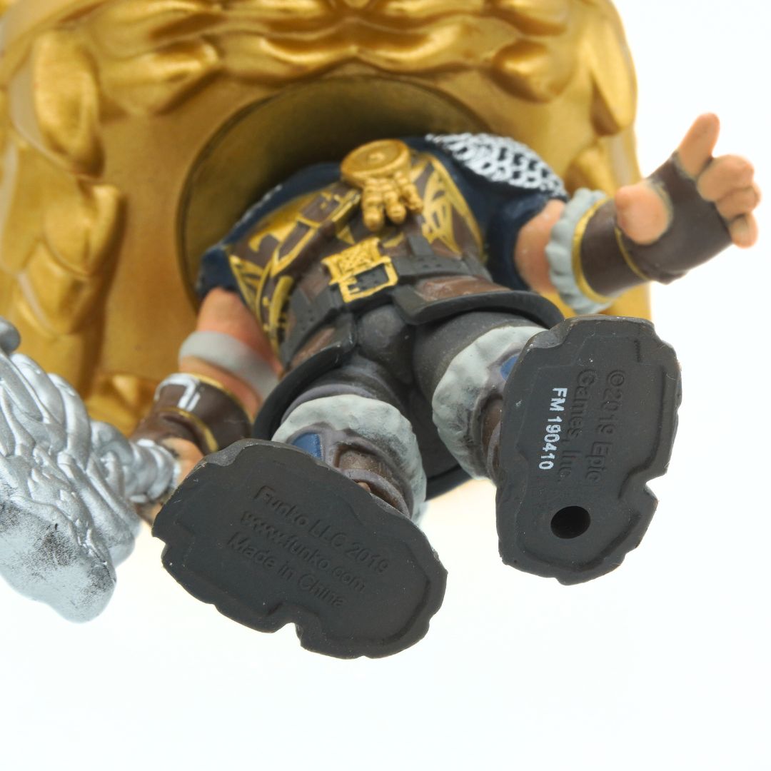 Close-up of a figurine with gold and black details on a white background