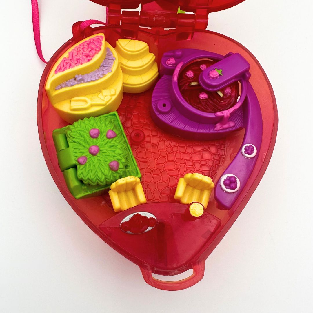 The bottom half of the 90s Polly Pocket Strawberry, displaying the shrub storage, seating and more