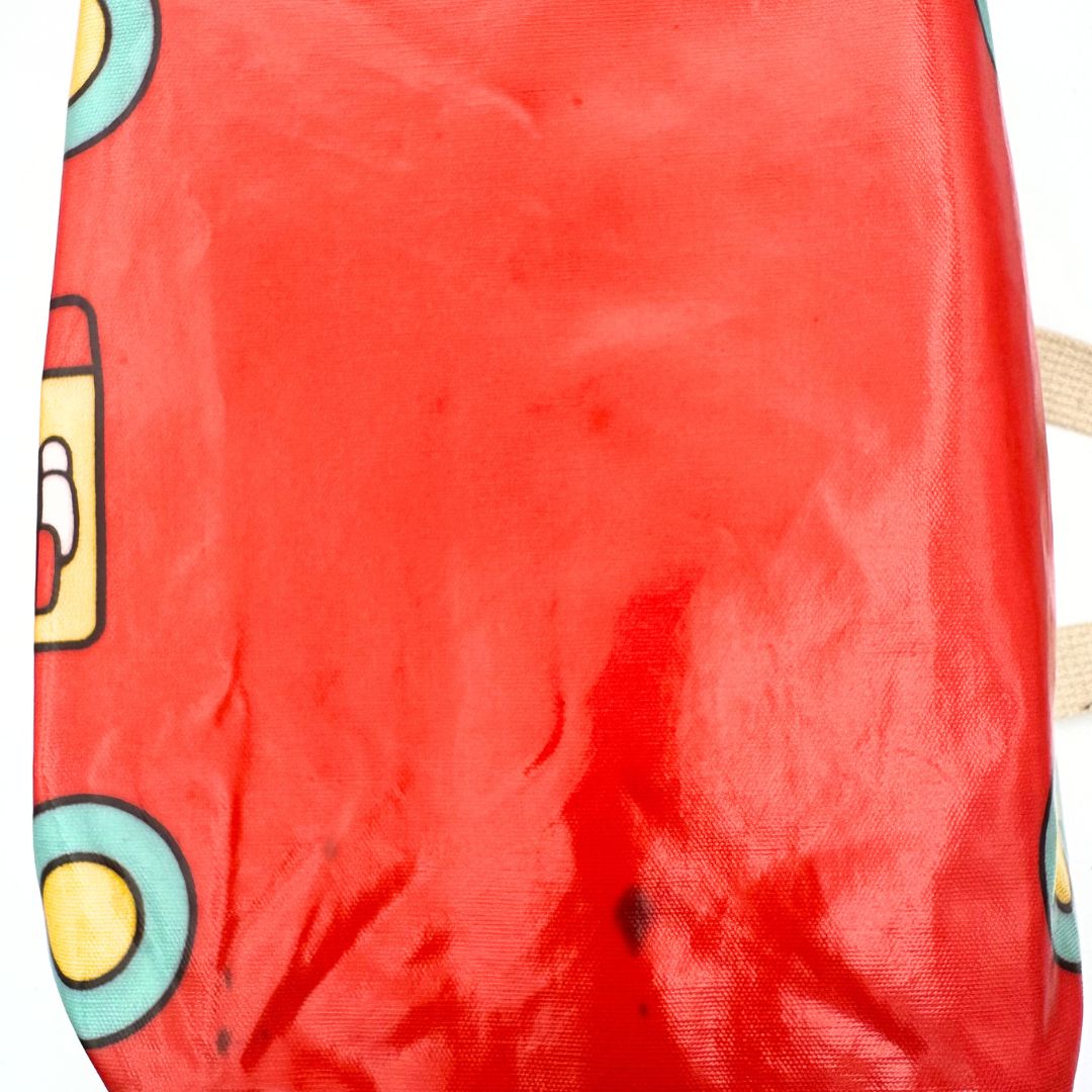 Underside of a vintage red Sanrio Hello Kitty bag with small ink stains