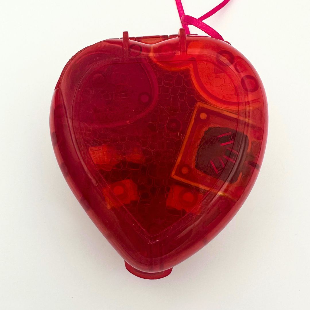 The bottom of the 90s Polly Pocket Fruit Surprise playset in the shape of a strawberry with a translucent exterior