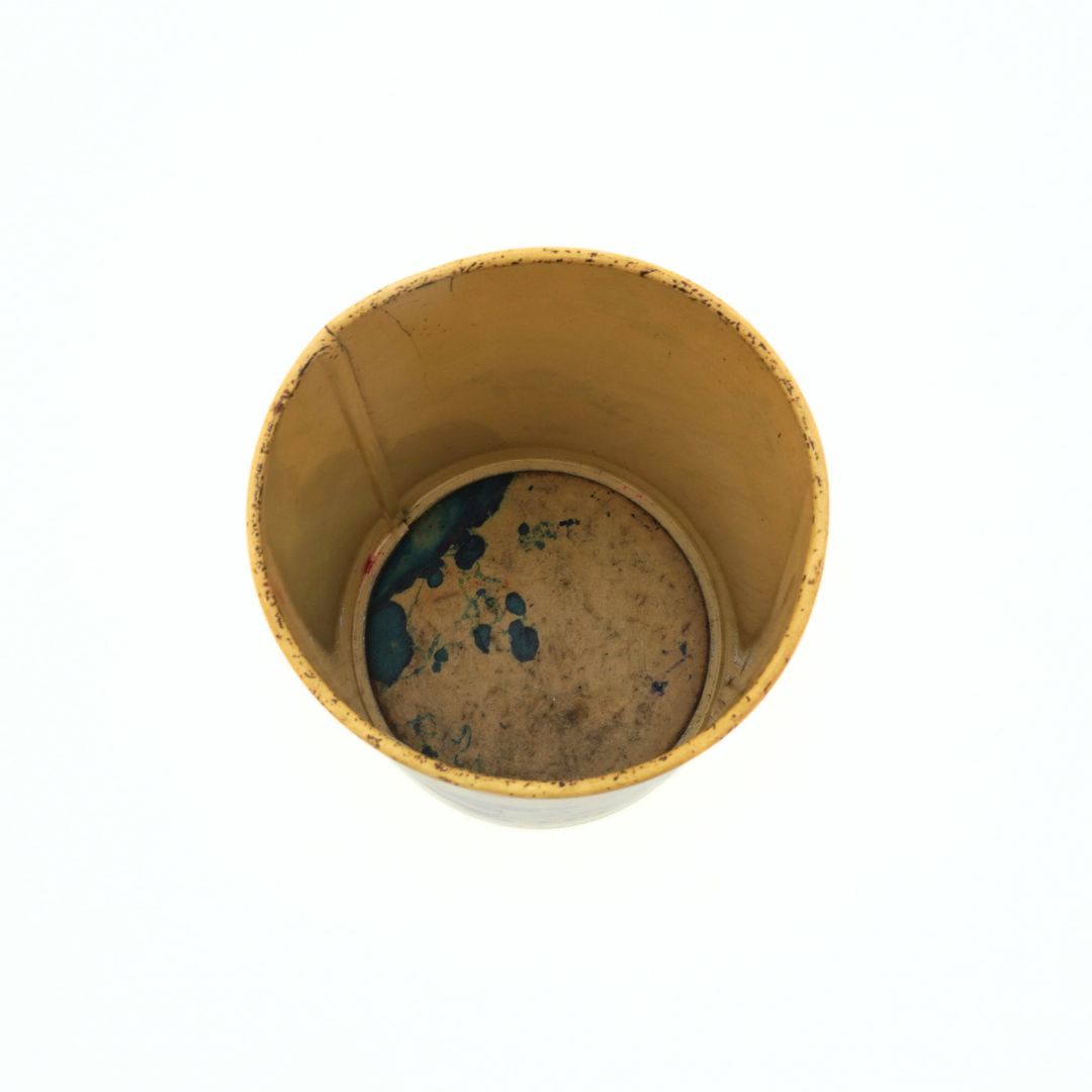 Photo of the inside of a light yellow Snoopy tin showing marks and wear