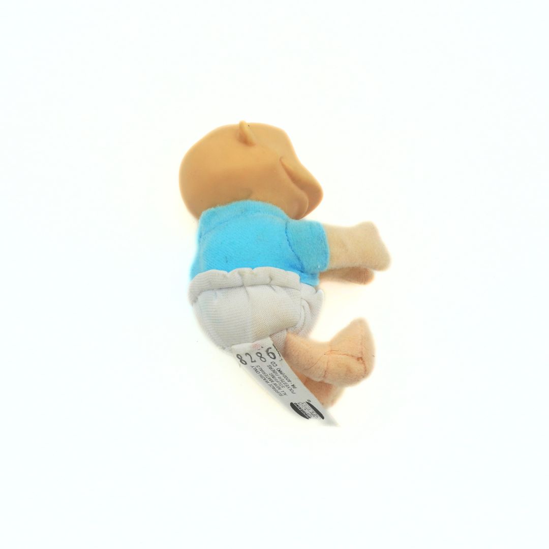 A 90s Tommy Rugrats toy with a solid plastic head and a soft plush body