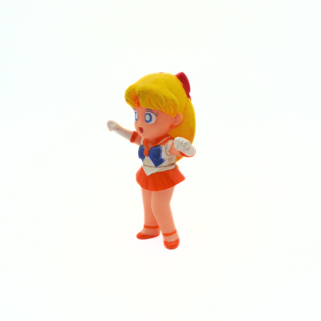 A 1994 Bandai Sailor Venus figurine with an orange and blue outfit and blonde hair