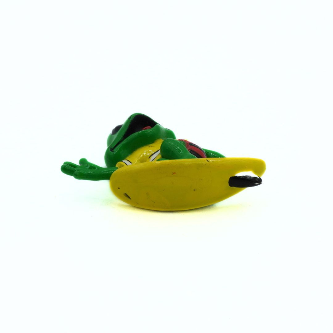 Green frog-shaped toy with a yellow surfboard on a white background