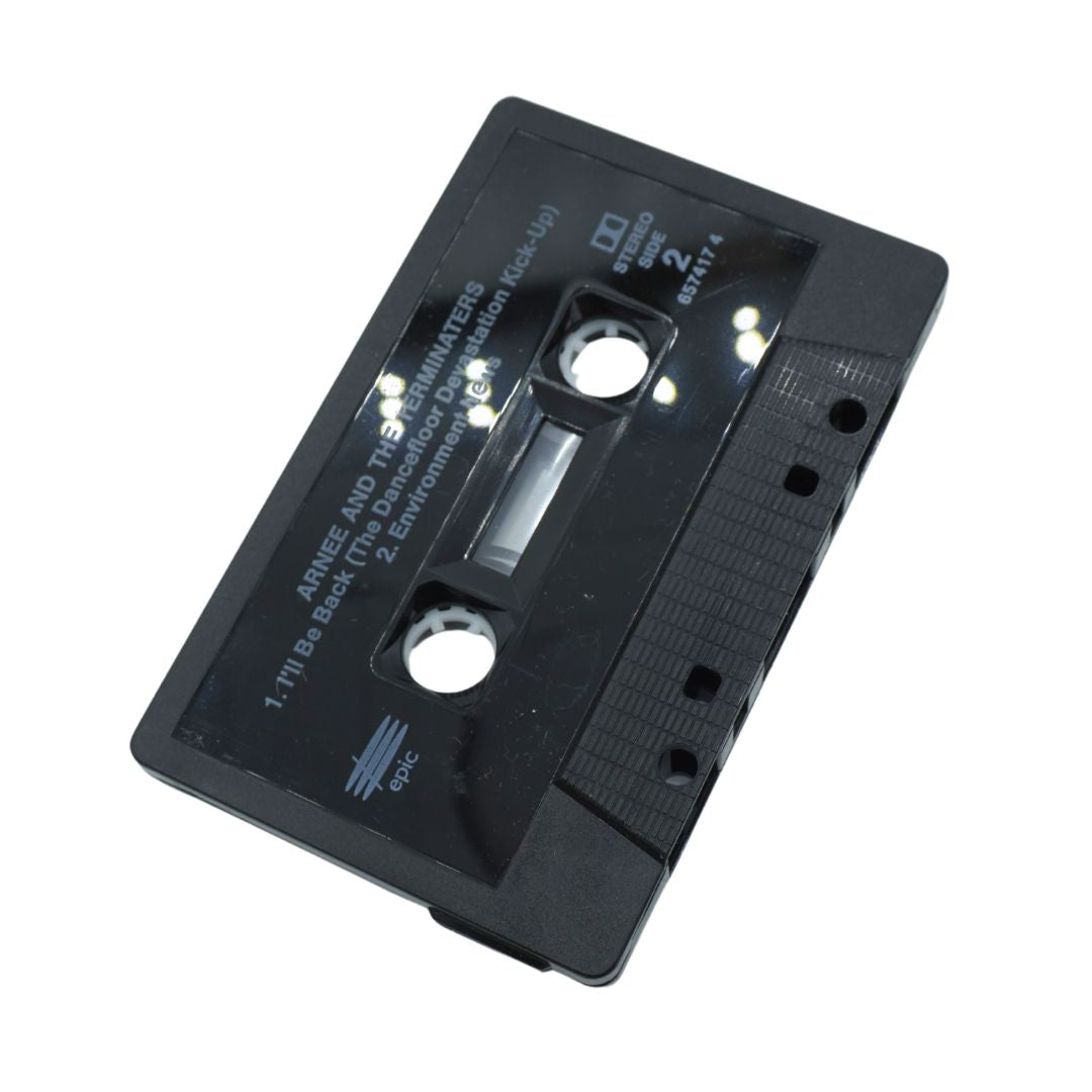 A black vintage audio cassette tape with printed white text, shown at an angle on a plain white background.