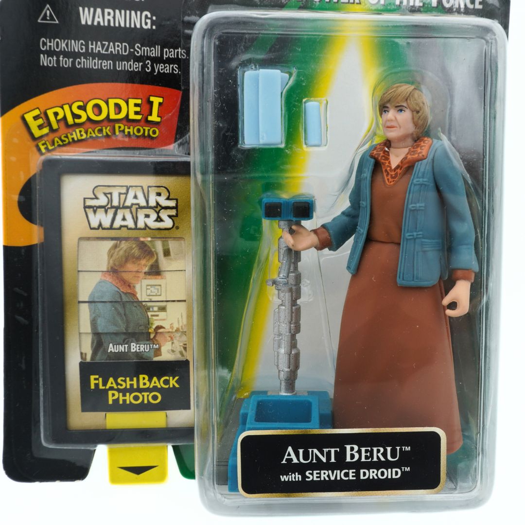 Close up of an unopened Star Wars Aunt Beru figure wearing a brown dress and blue jacket