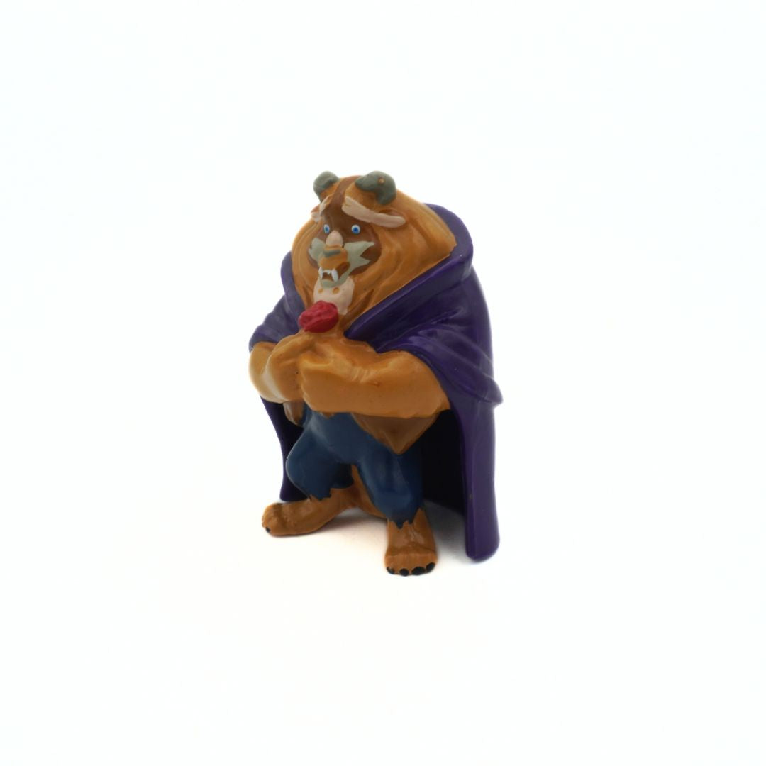 A Beauty and the Beast Mini Figure holding a red rose and wearing a purple cloak
