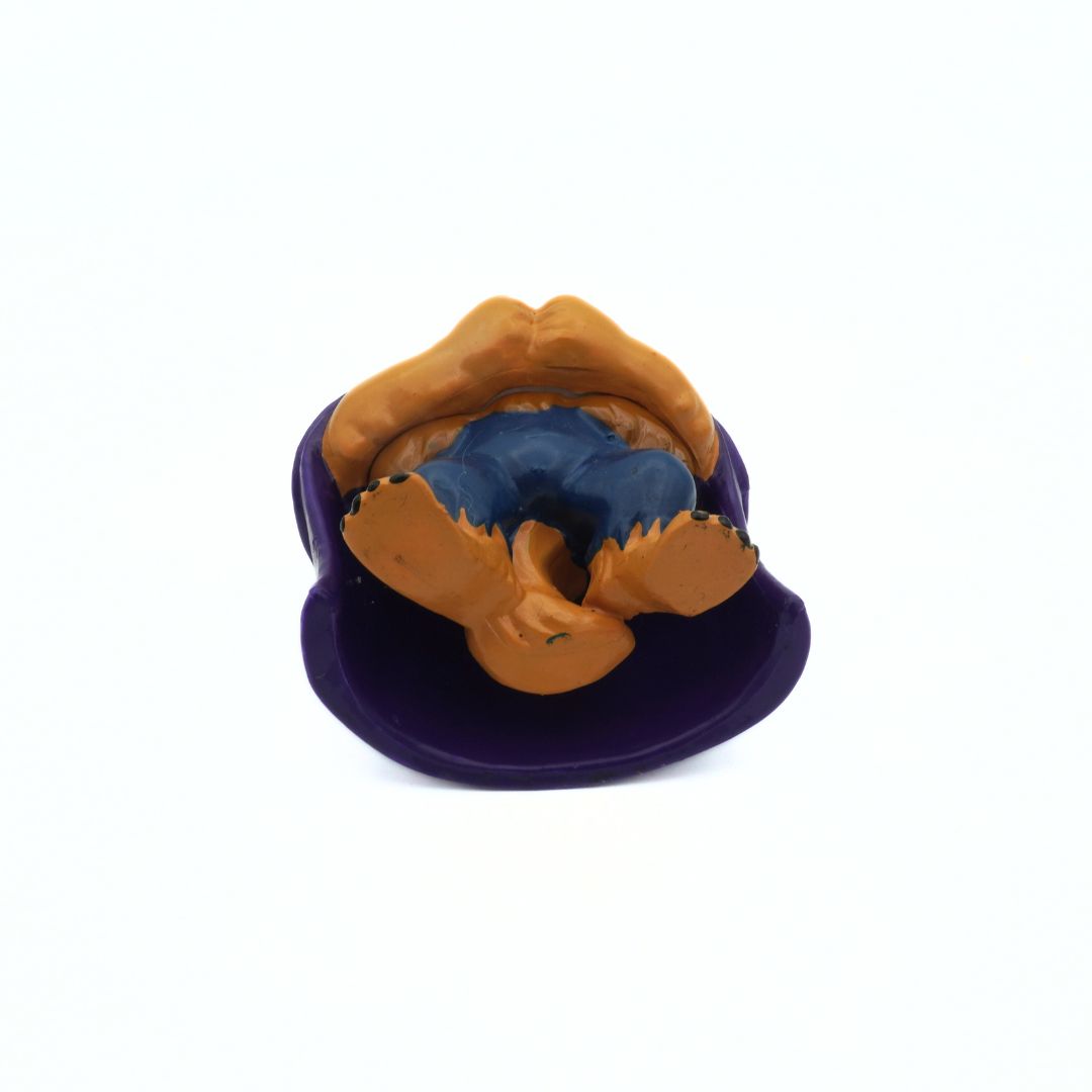 Underside of a vintage Beauty and the Beast figure showing his brown pants and purple cloak