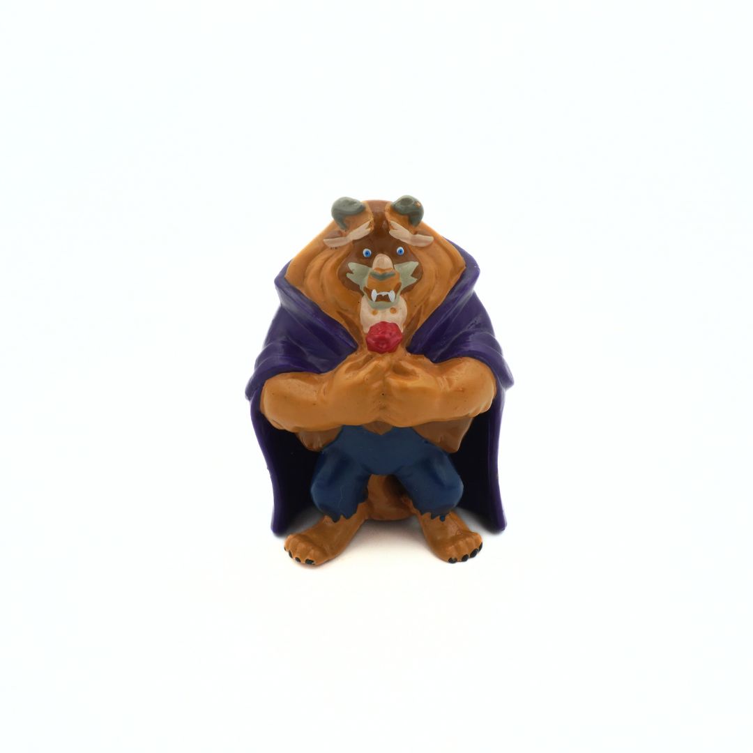A Beauty and the Beast Mini Figure holding a red rose and wearing a purple cloak