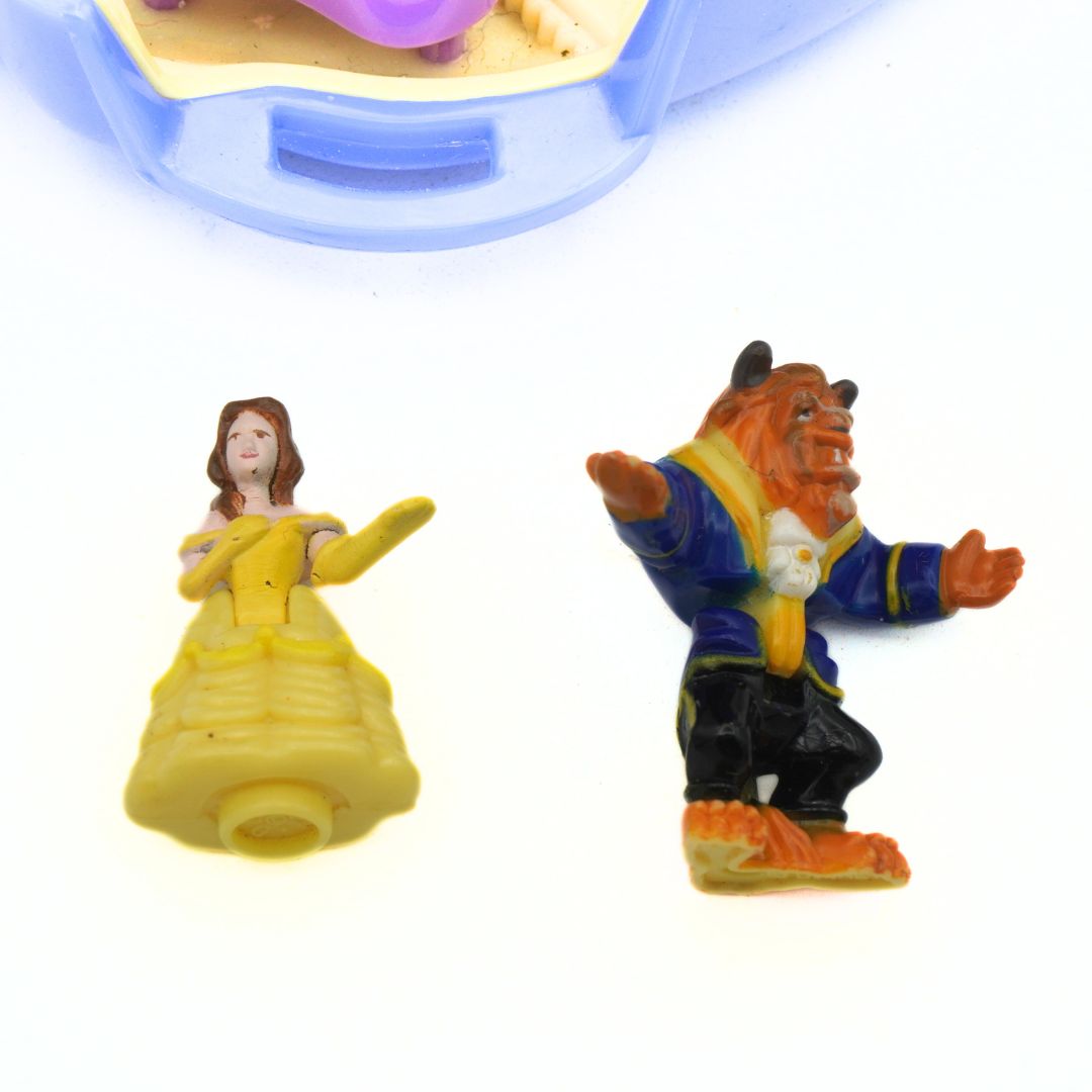 Figurines of a princess and a beast from 'Beauty and the Beast' on a white background