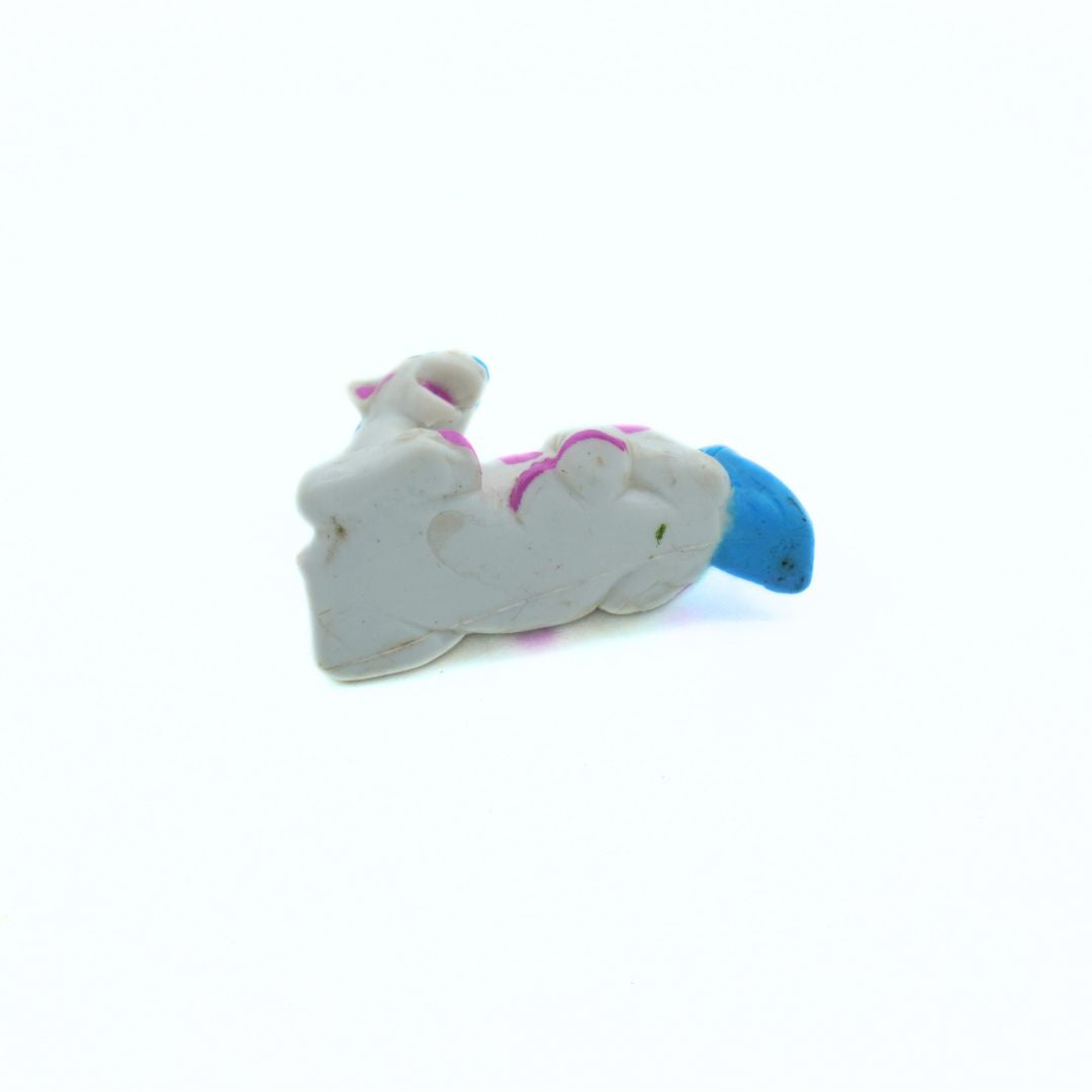 Toy figure of a white hourse with a blue mane on a white background