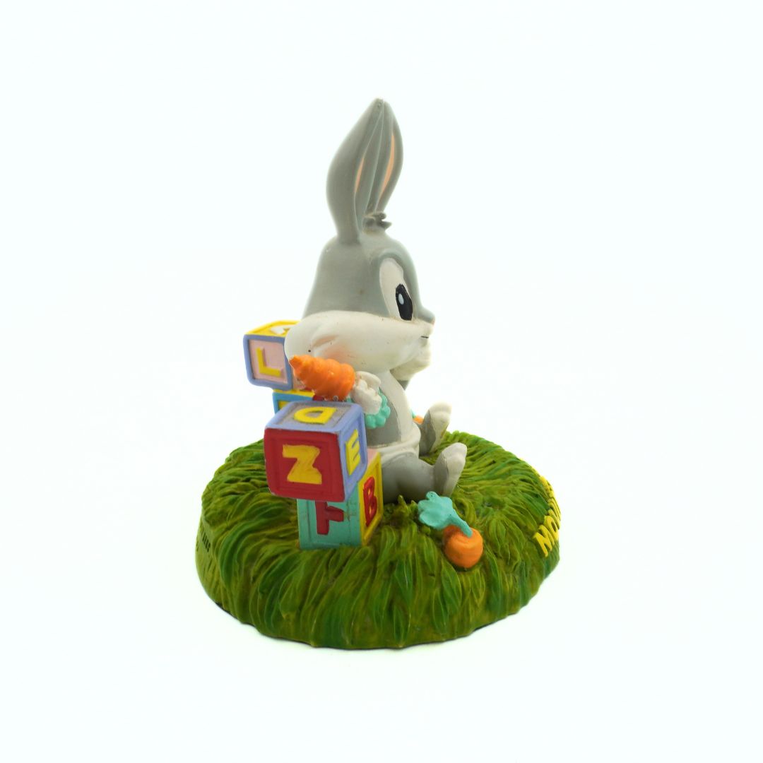 Toy figure of a rabbit with alphabet blocks on a grassy base