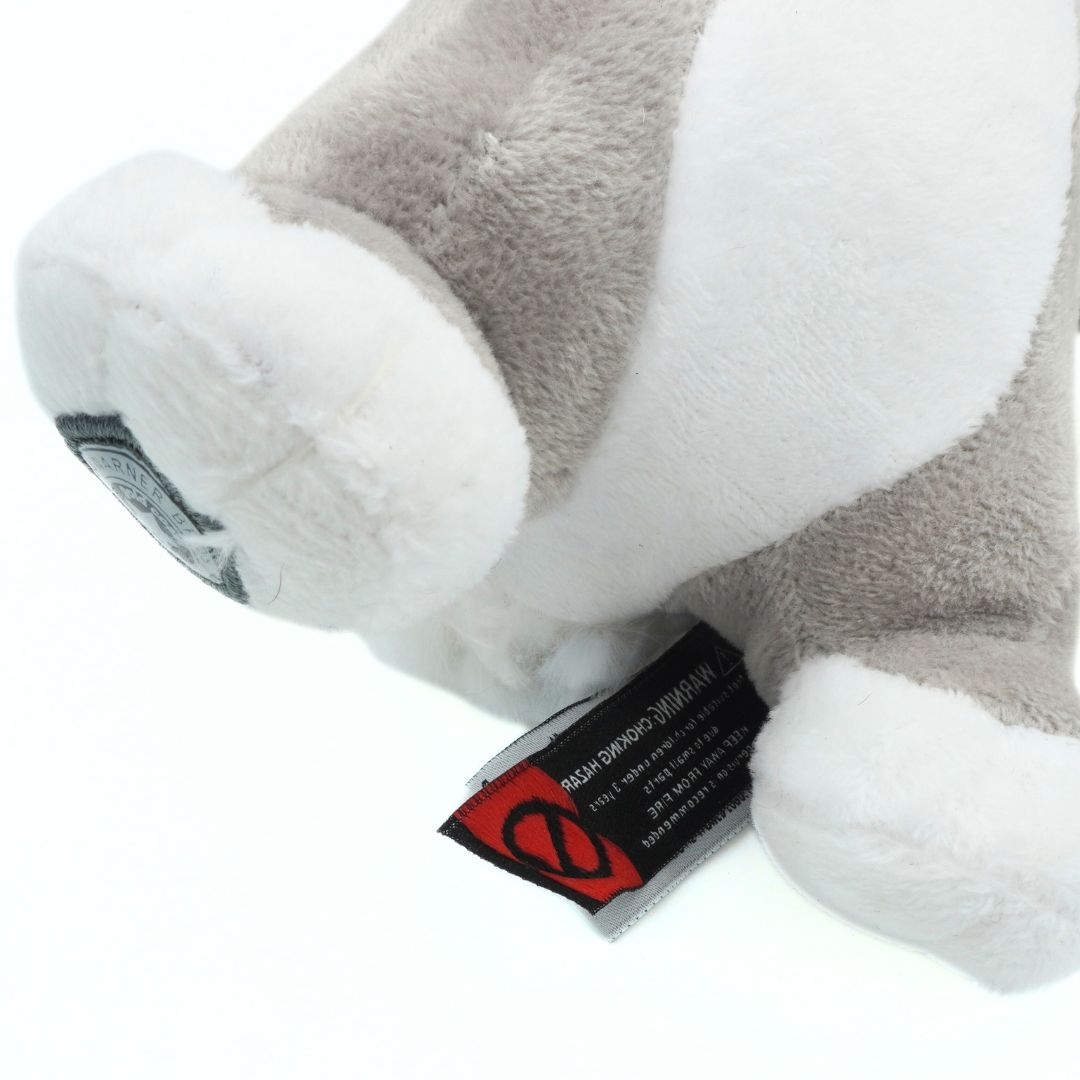 Close-up of a plush toy with a visible brand tag on a white background