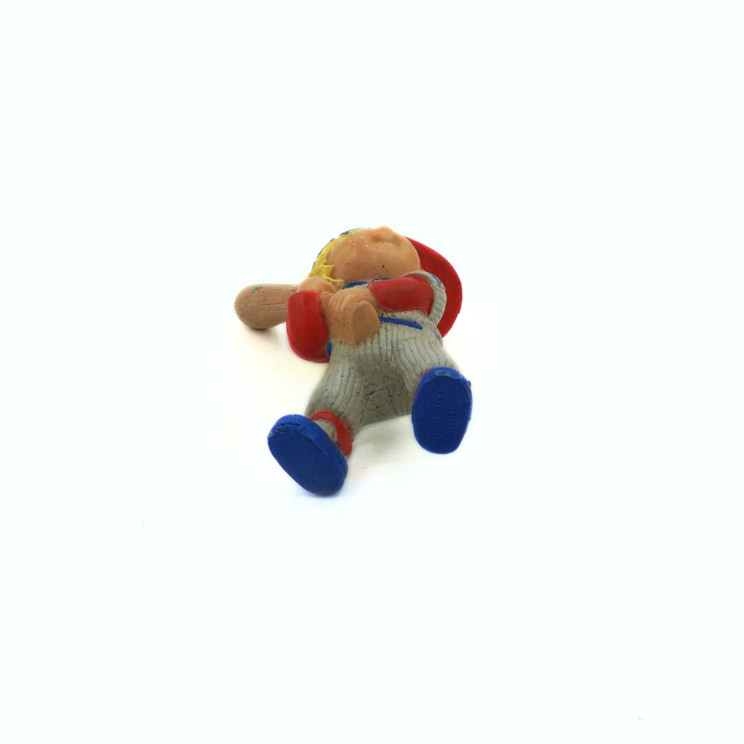 Small teddy bear with a red hat and blue shoes on a white background