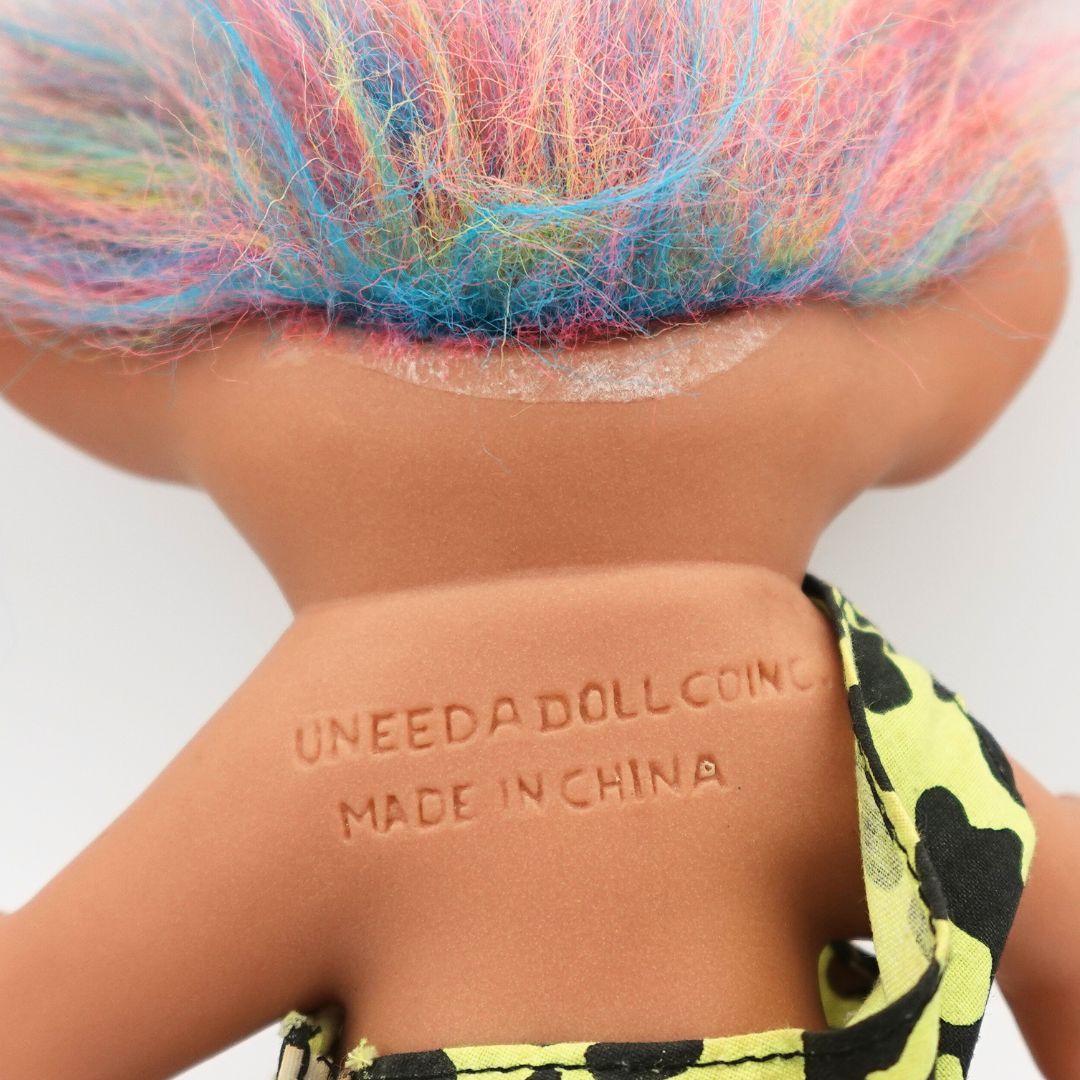 Closeup of the glue residue and Uneeda branding on the vintage Caveman Troll Doll