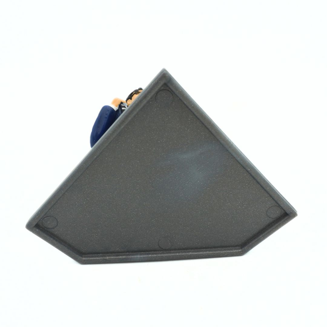 Underside of a vintage 1995 Superman Clark Kent figurine on a silver stand