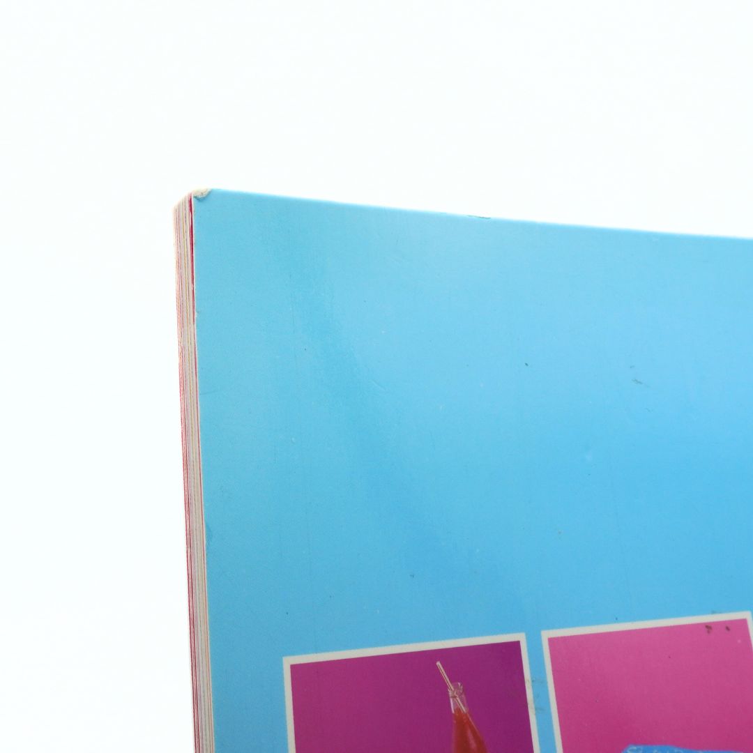 Close-up of a blue notebook with pink and white design on a white background