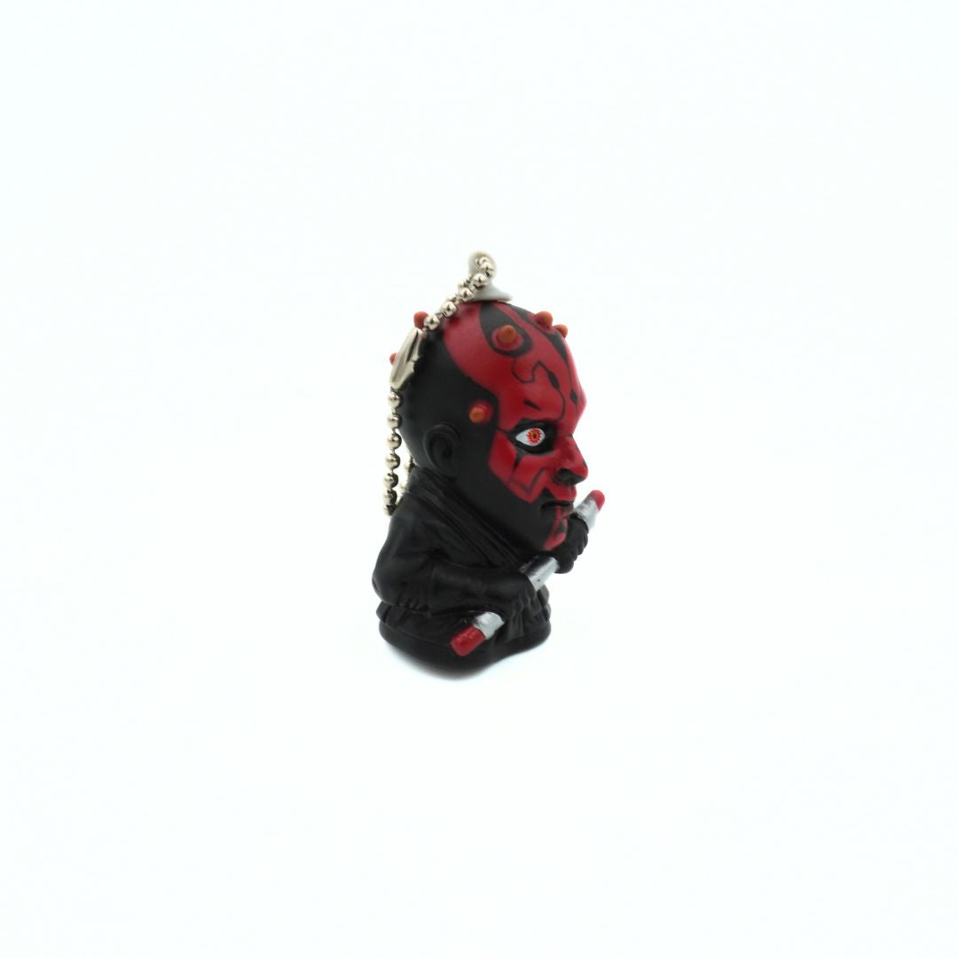 A vintage Star Wars Darth Maul keychain holding his dual ended lightsaber
