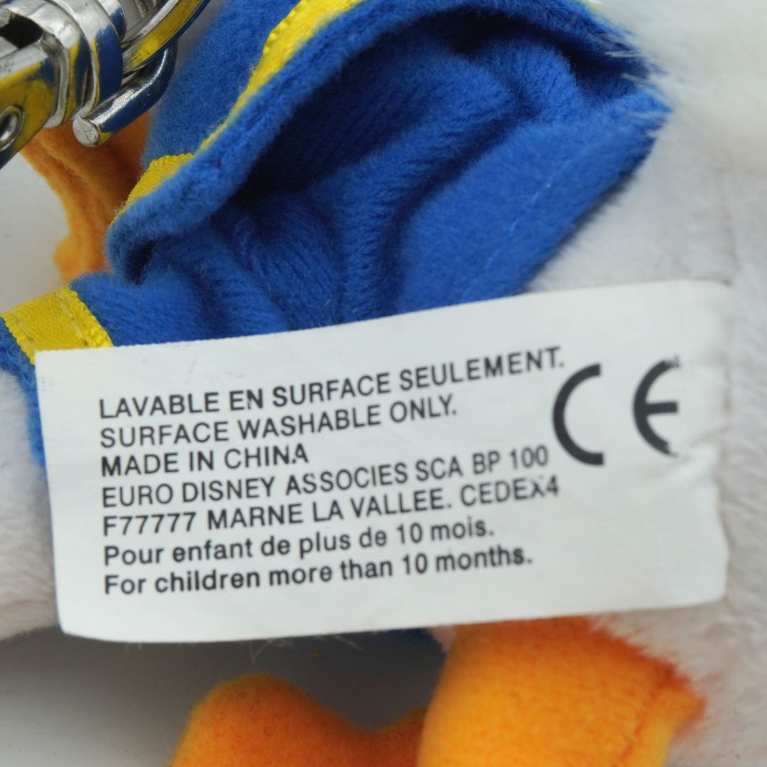 Close-up of a label on a plush toy with text and symbols.