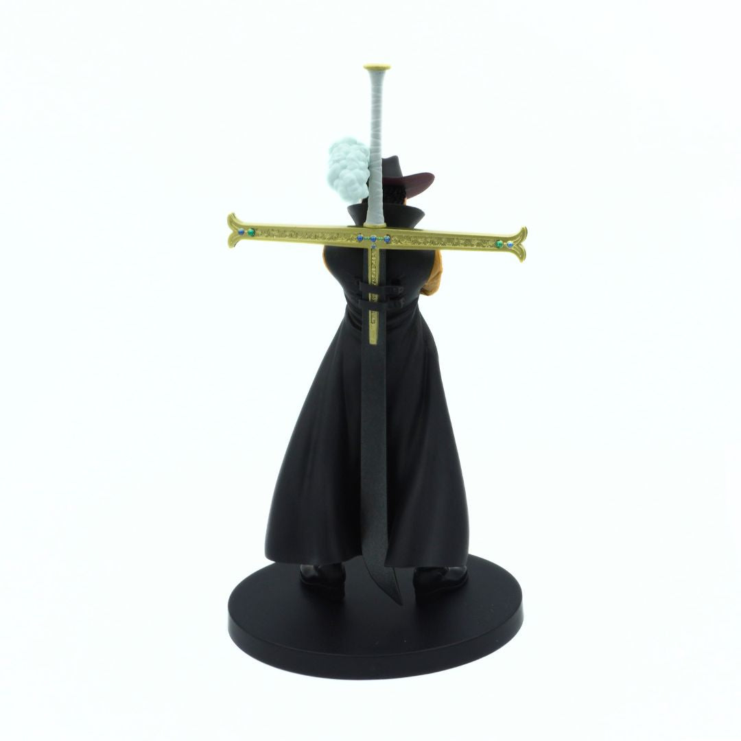 Photo of the back of a One Piece Dracule Mihawk figurine on a black stand wearing a black outfit with a blue plume on his hat