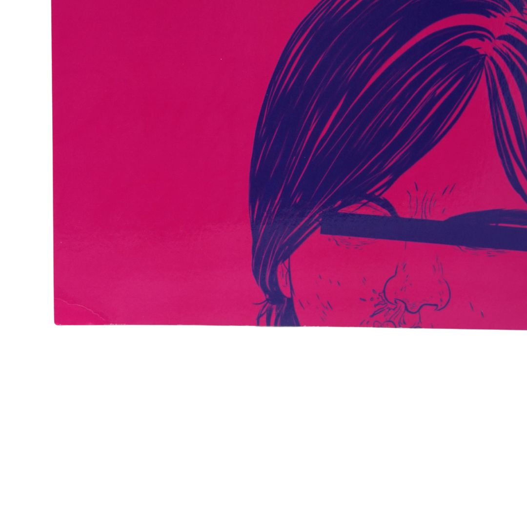 A close-up of a graphic art print featuring a stylized illustration of a person with dark hair and glasses on a vibrant magenta background, shown against a white studio backdrop.