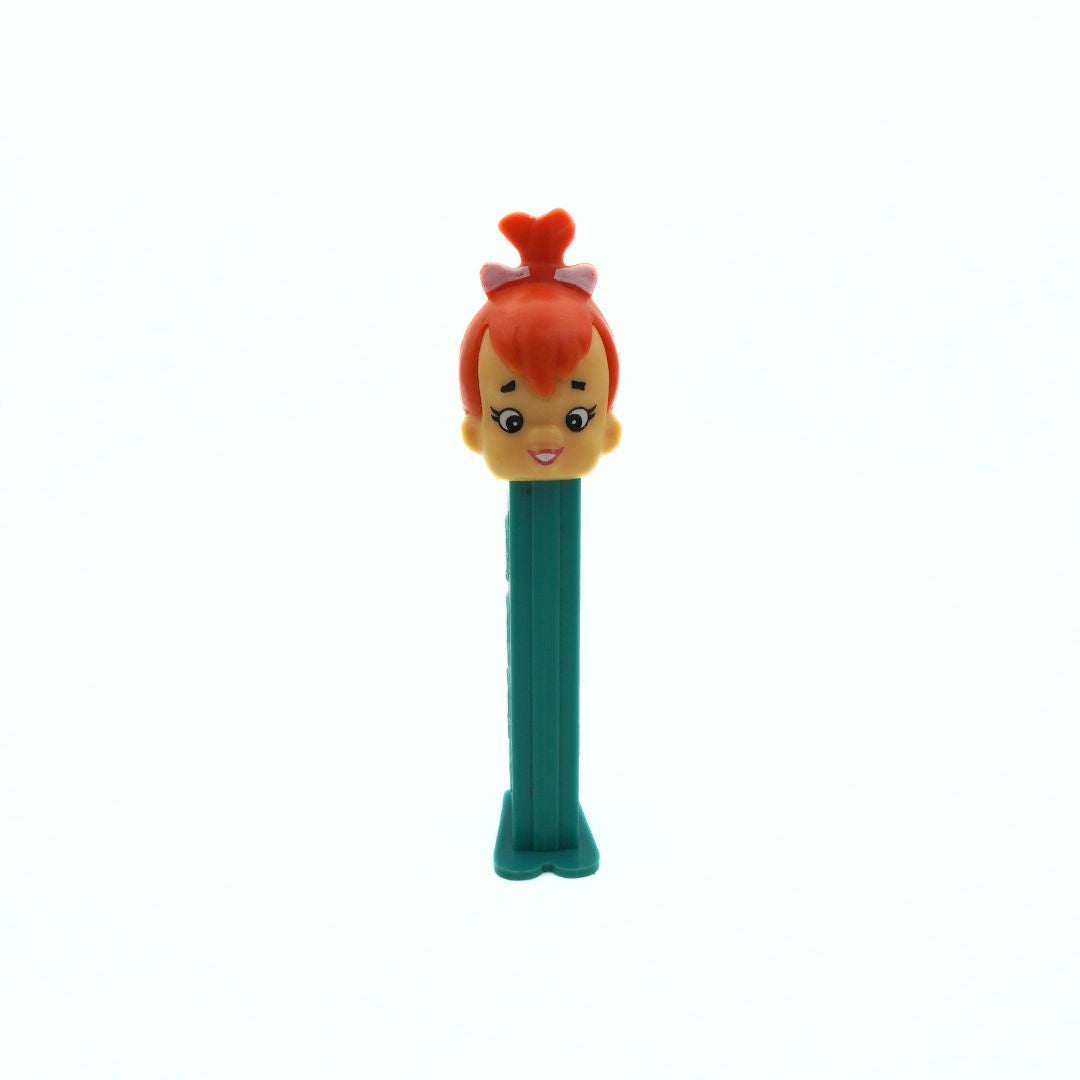 A vintage Pez dispenser of Pebbles from the Flinstones, with a green body