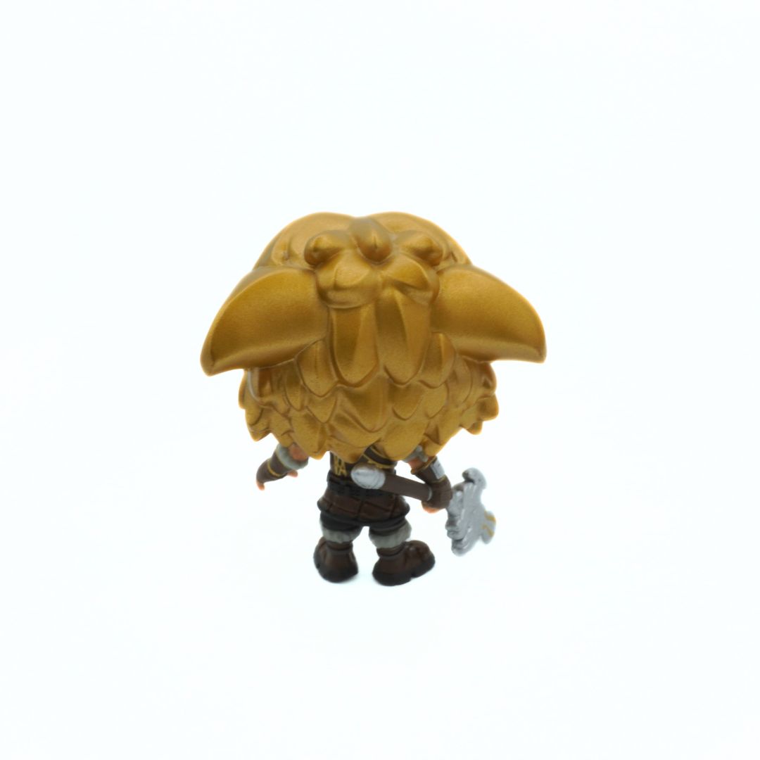 Gold-colored figurine of a creature with a large beak on a white background