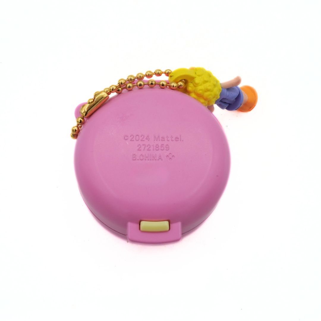 Pink round container with a colorful keychain on a white background