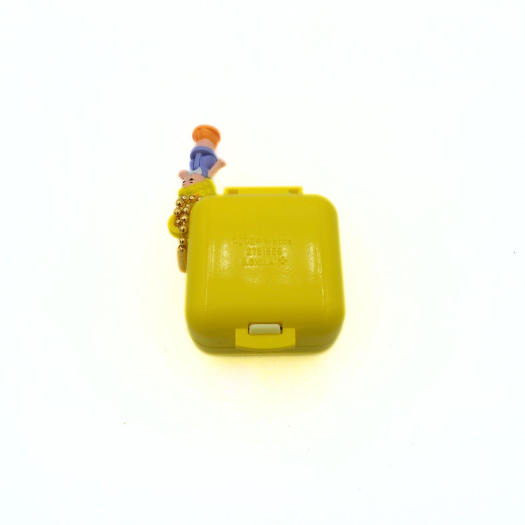 Yellow toy with a small character on top against a white background