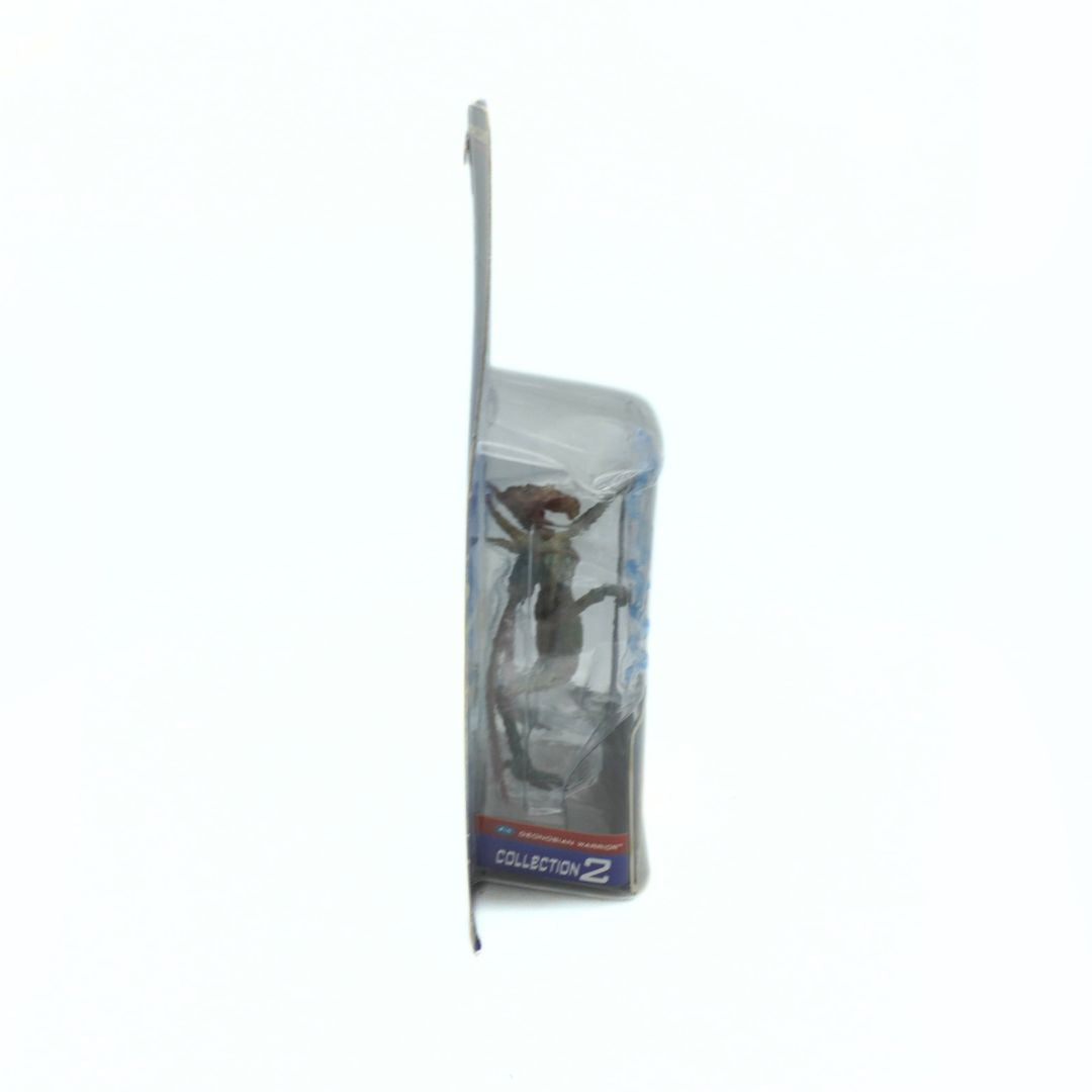 Side on photo of a 2001 Geonosian Warrior figurine in its original packaging