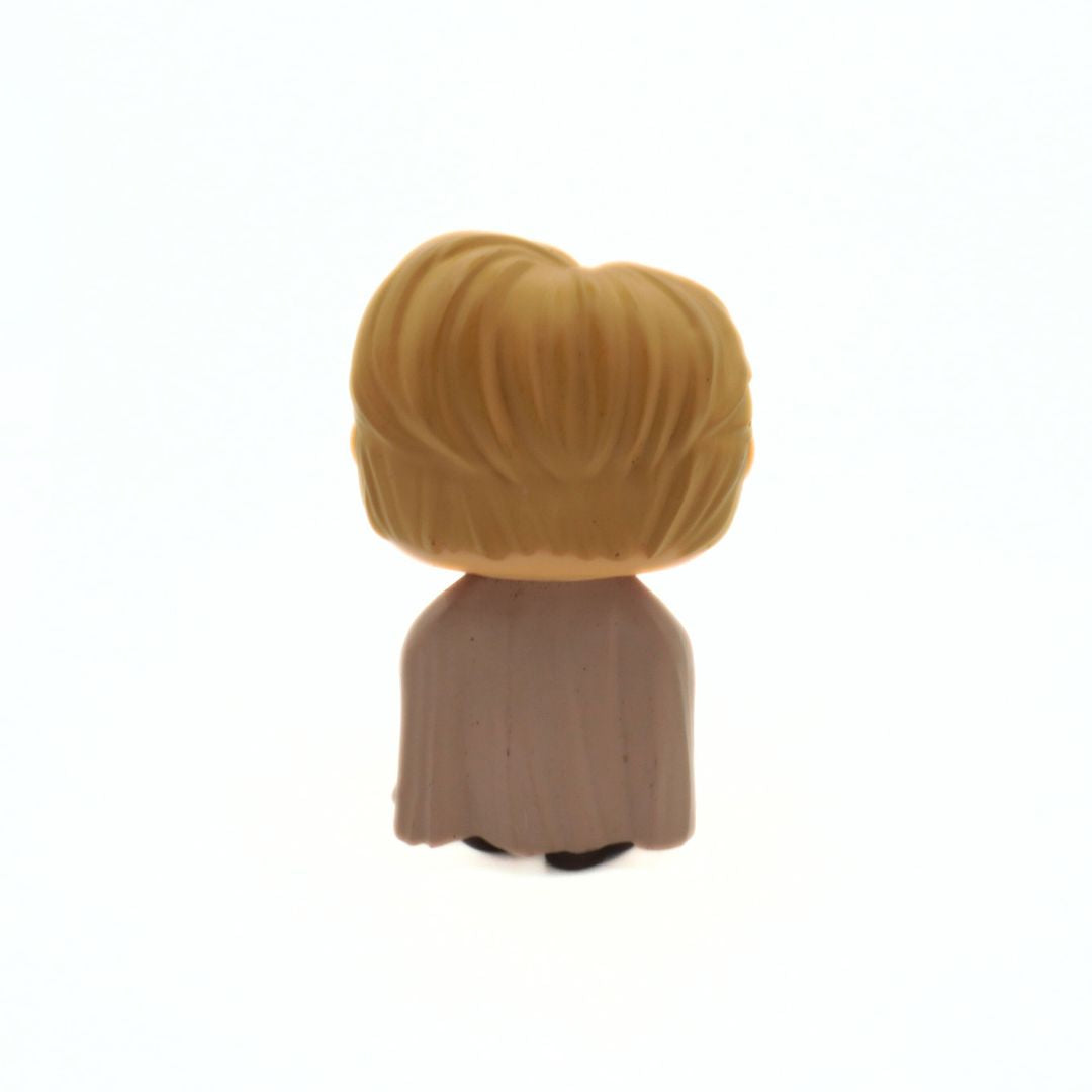 Small figurine with blonde hair and a brown outfit on a white background