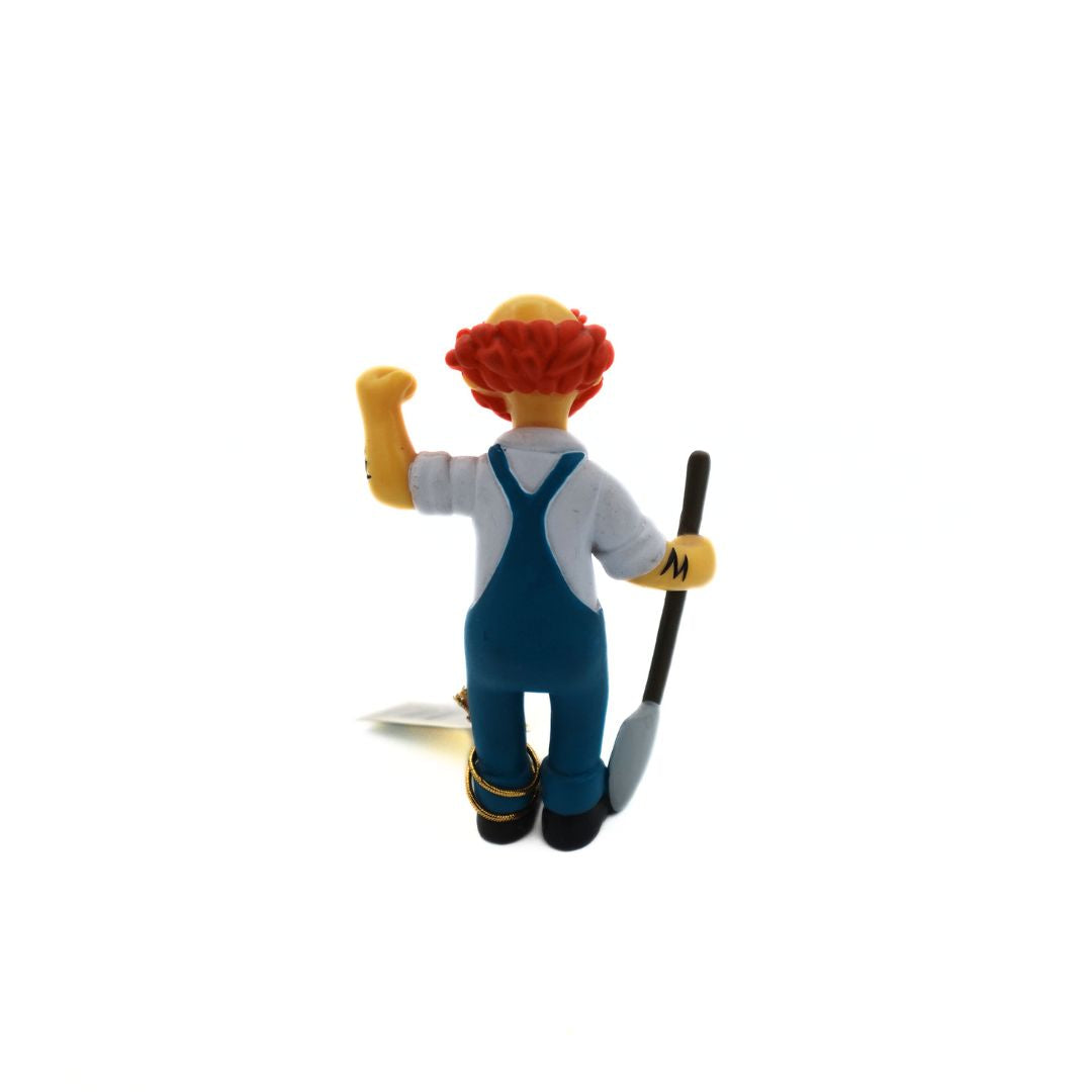 Photo of the back of a 2005 Simpsons figurine showing Groundskeeper Willie with a shovel and blue overalls