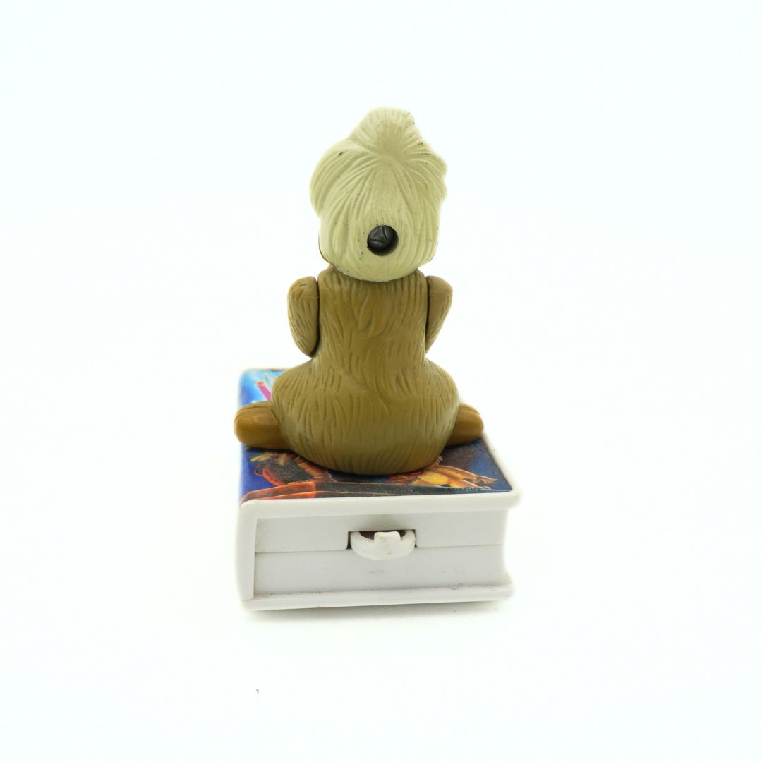 A vintage 90s McDonalds toy of Gurgi sitting on a VHS-shaped stand of The Black Cauldron