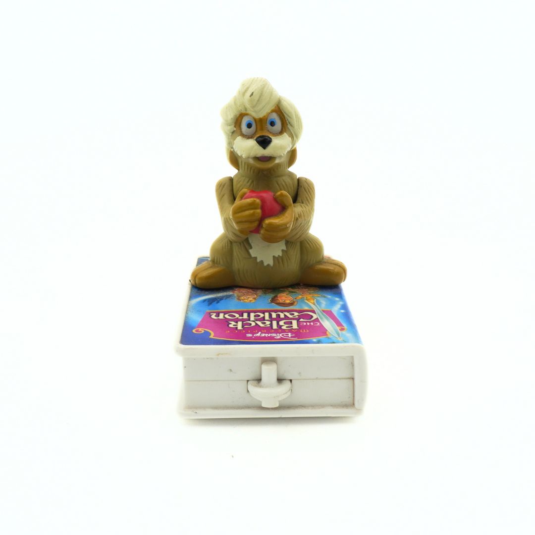 A vintage 90s McDonalds toy of Gurgi sitting on a VHS-shaped stand of The Black Cauldron