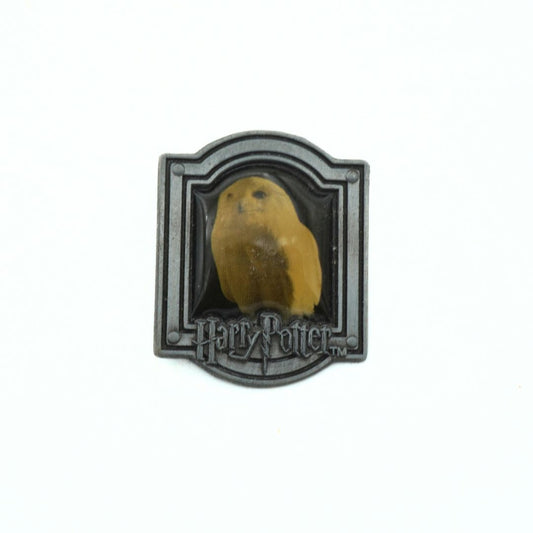 Hogwarts crest badge with a yellow owl on a white background