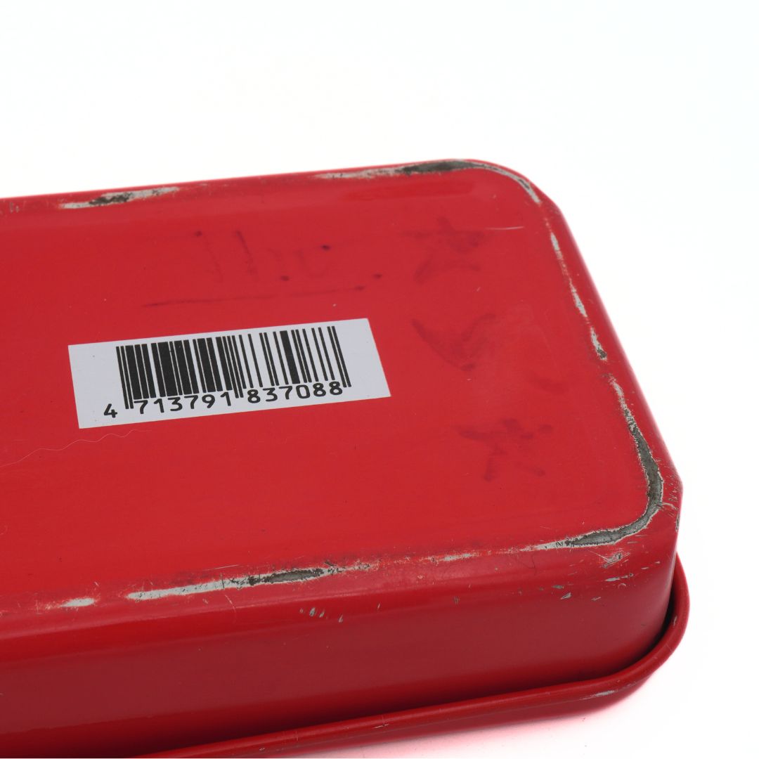Red metal box with a barcode label on a white background