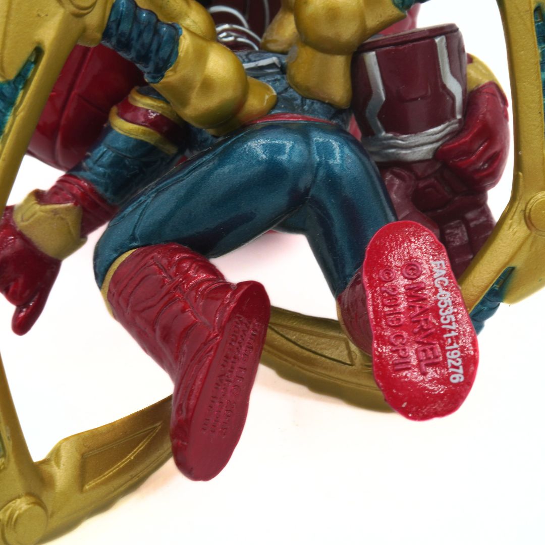 Close-up of a superhero figurine with red boots on a white background