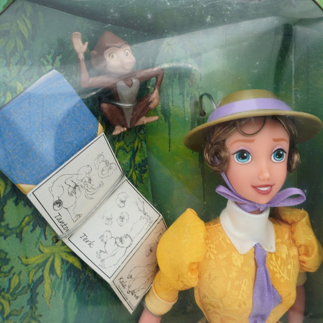 A closeup of the 1999 Jane Tarzan doll showing her sketchbook and monkey
