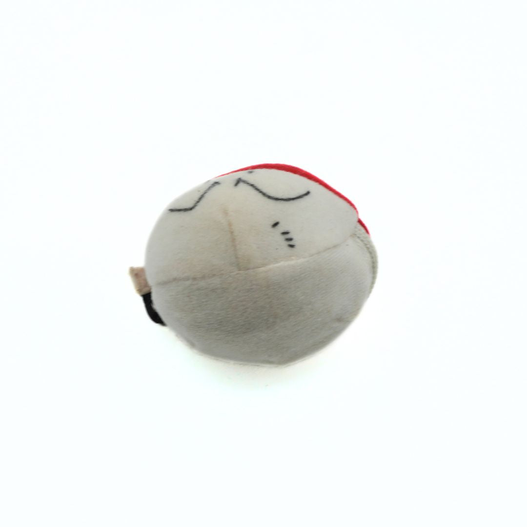 Round gray plush toy with a red top on a white background