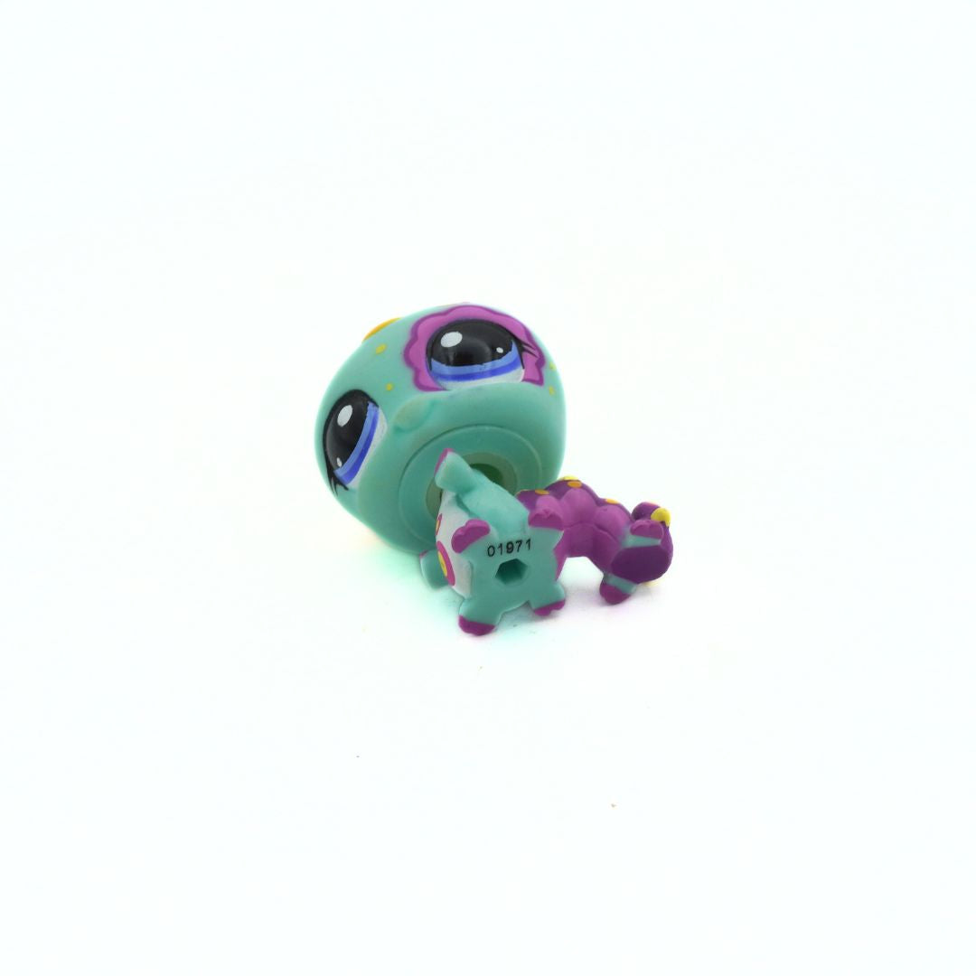 Small green and purple toy figure on a white background