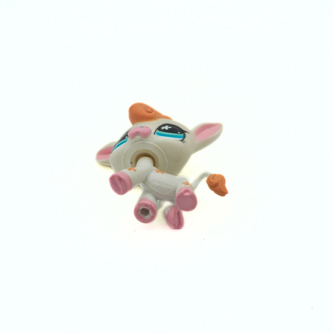 Small figurine of a cartoon-like creature with pink accents on a white background