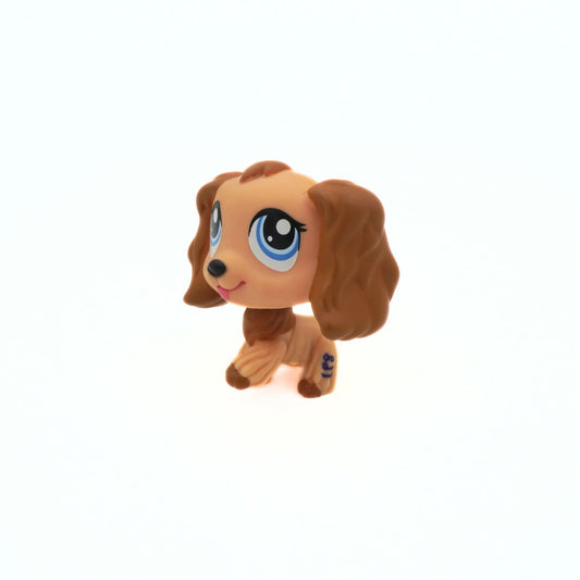 Small brown dog figurine with large blue eyes on a white background