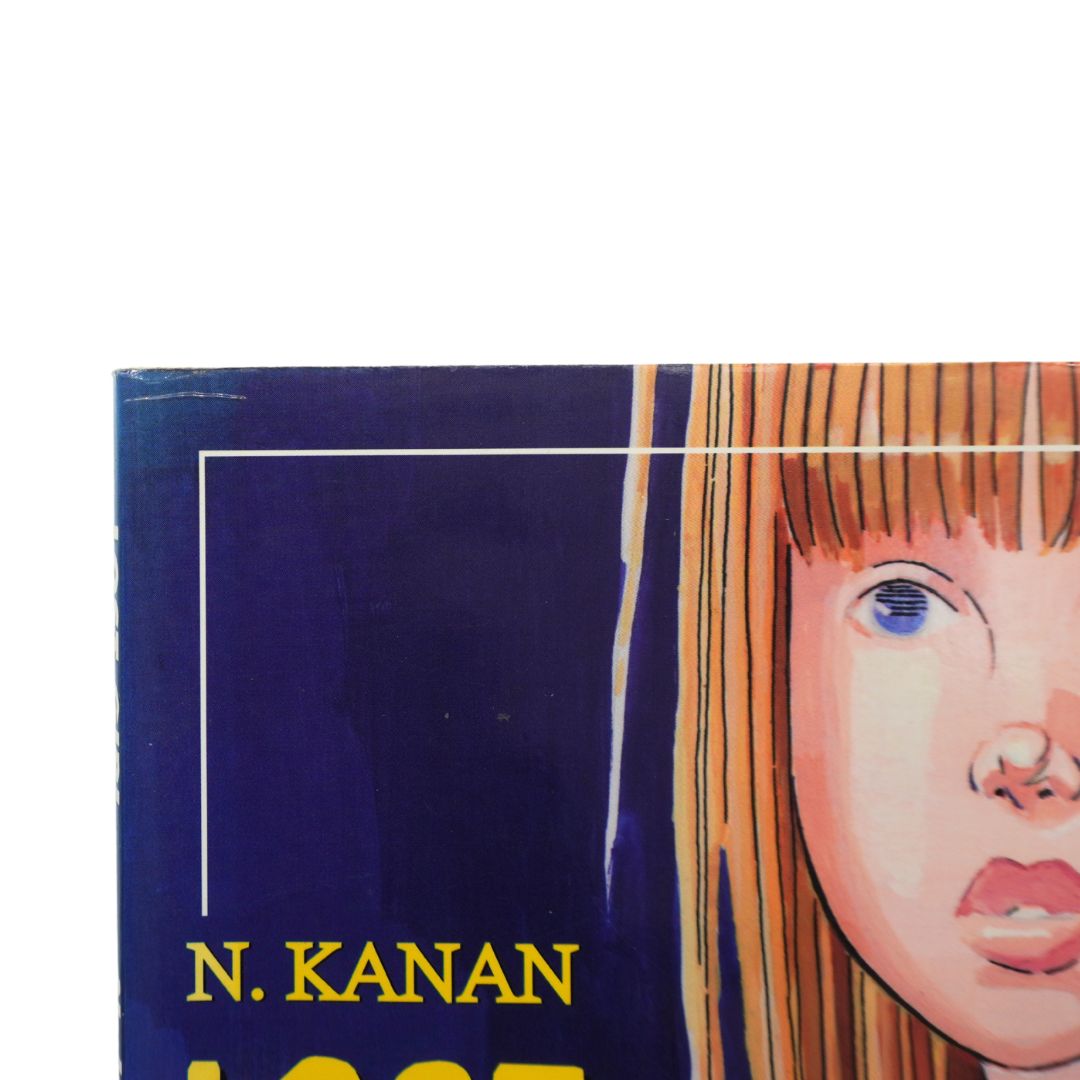 A close-up of a book cover featuring a stylized illustration of a child's face with orange hair against a dark blue background, with the text 'N. KANAN' visible.