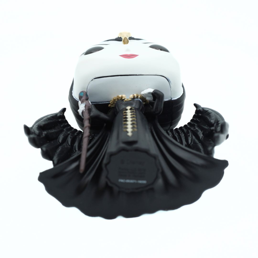 A collectible figurine of a stylized female character resembling Lady Gaga's Black Album era, featuring a white head with black eyes and red lips, a black dress with gold trim, and black wings, shown against a plain white background.
