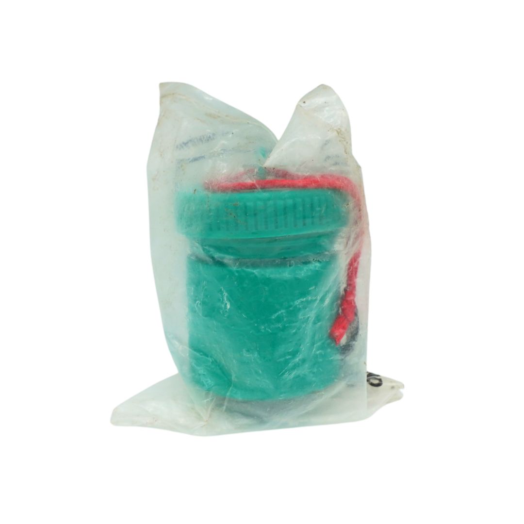 A green plastic cylindrical component inside a crinkled clear plastic bag with a red strap, shown on a plain white background.